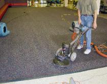 Picture shows employee doing some commercial carpet cleaning in a commercial facility